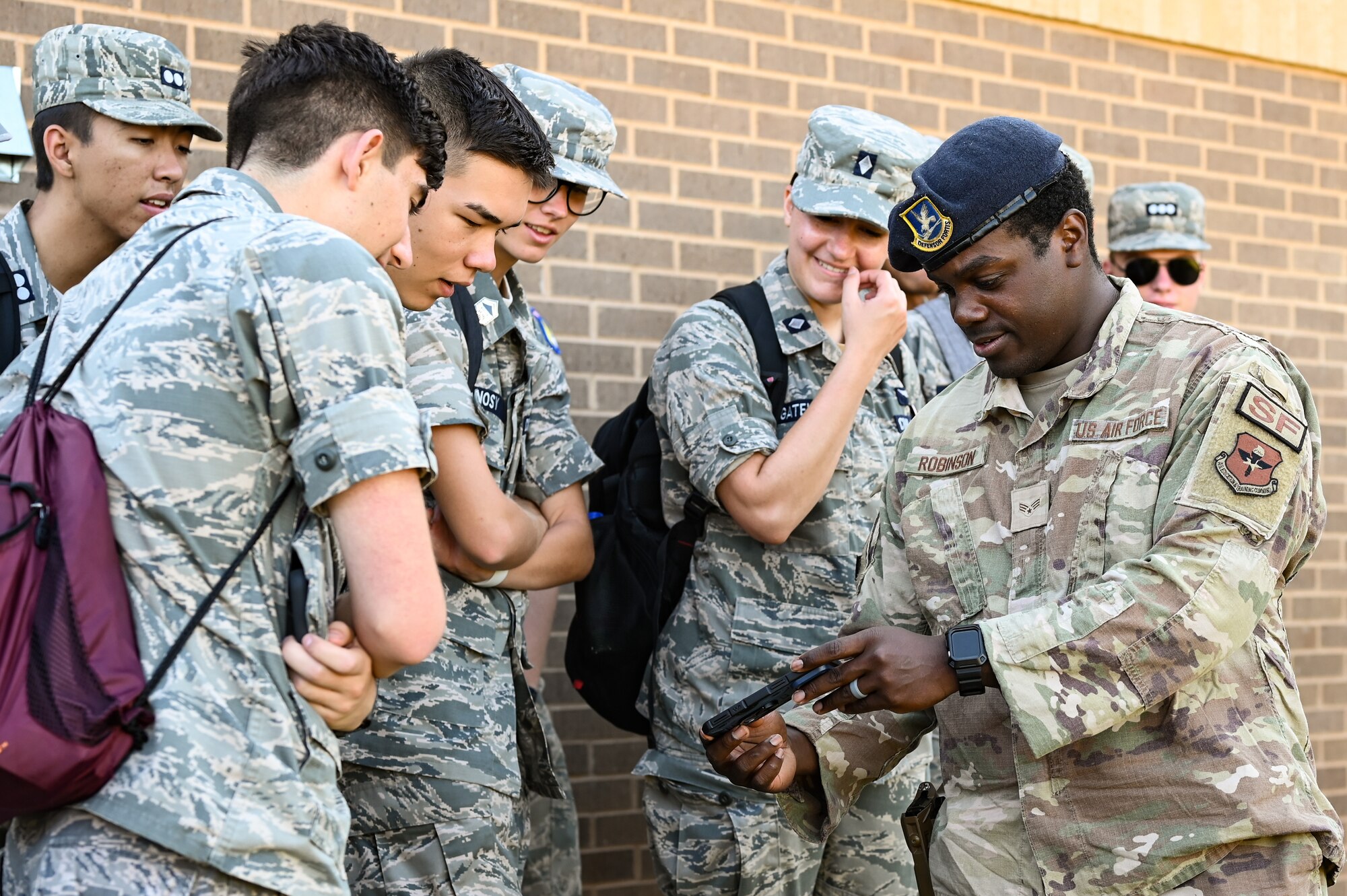 U.S. Air Force Senior Airman Taderius Robinson (right), 47th Security Forces Squadron military working dog handler, shows Civil Air Patrol cadets a photo of a military working dog at Laughlin Air Force Base, Texas, June 28, 2023.