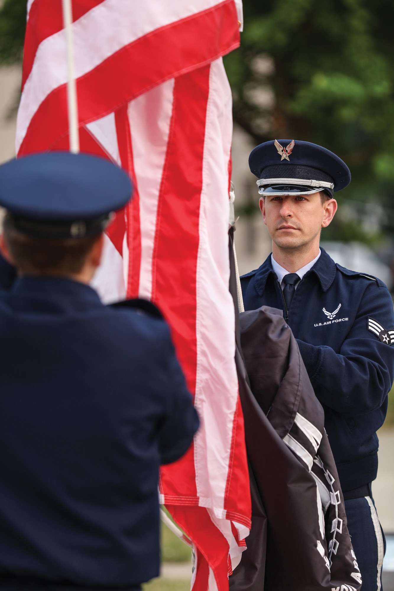 Senior Airman Zechariah Gerardi, right, 445th Airlift Wing Command Post, and Airman 1st Class Ethan Pottorf, 88th Healthcare Operations Squadron train on lowering and raising the flag, June 4, 2023.