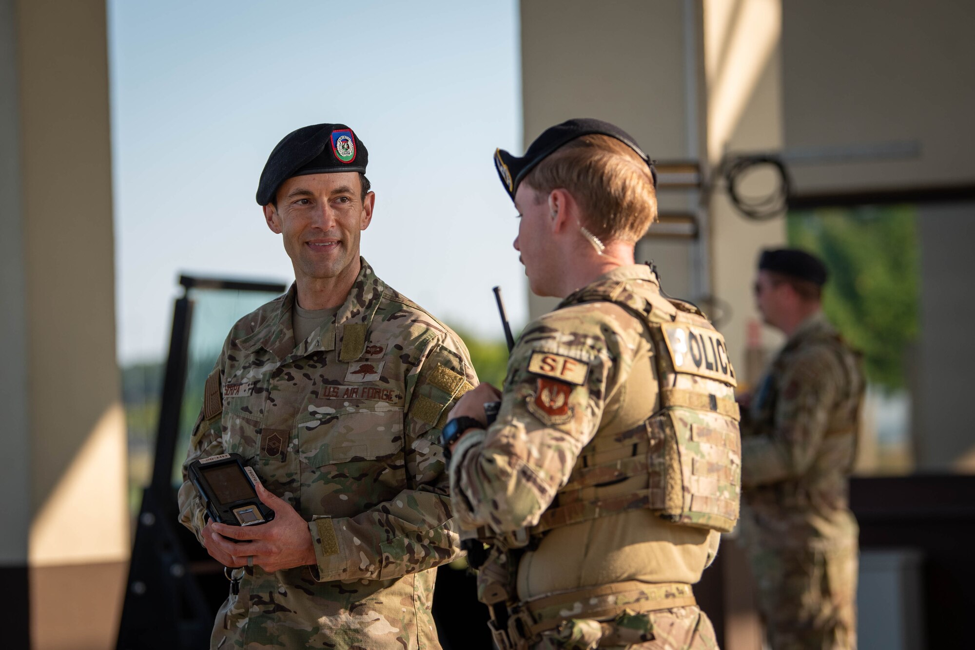 U.S. Air Force Chief Master Sgt. Evan Serpa, 52nd Fighter Wing command chief (left), discusses security procedures with Airman 1st Class Mark Schmuckey, 52nd Security Forces Squadron member, at the main gate for Spangdahlem Air Base, Germany.
