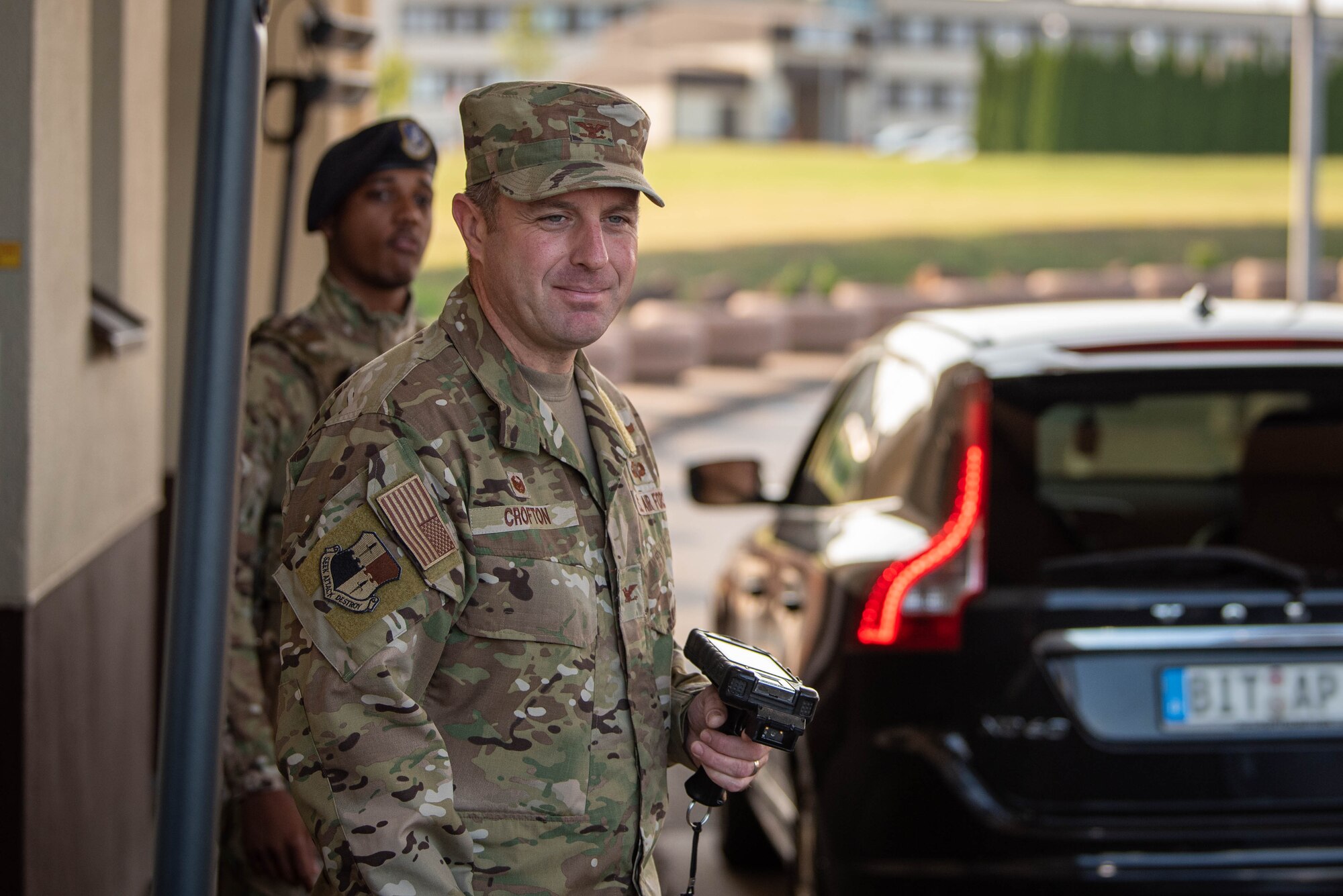 U.S. Air Force Col. Kevin Crofton, 52nd Fighter Wing commander, checks IDs at the main gate for Spangdahlem Air Base, Germany.