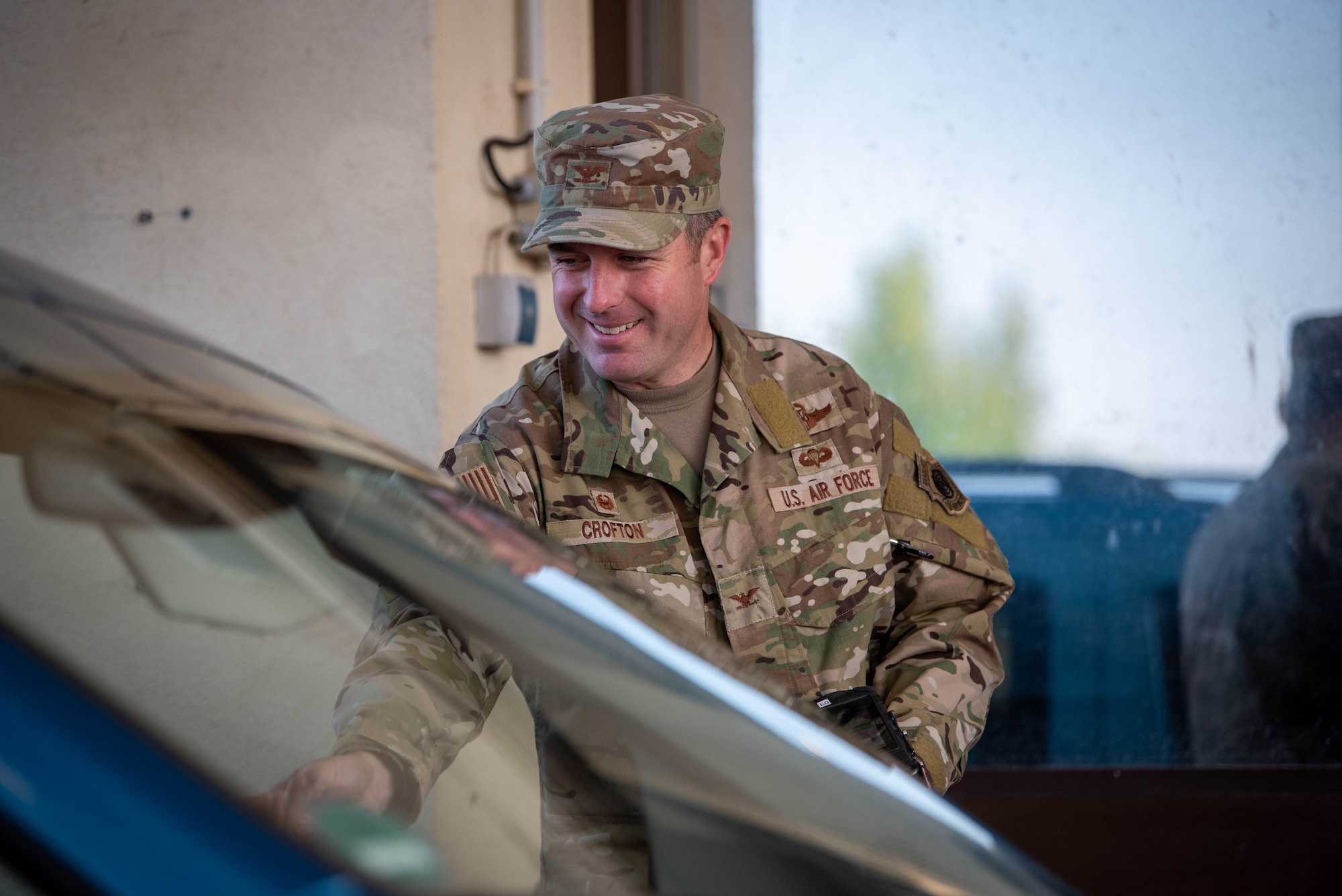 U.S. Air Force Col. Kevin Crofton, 52nd Fighter Wing commander, checks IDs at the main gate for Spangdahlem Air Base, Germany.