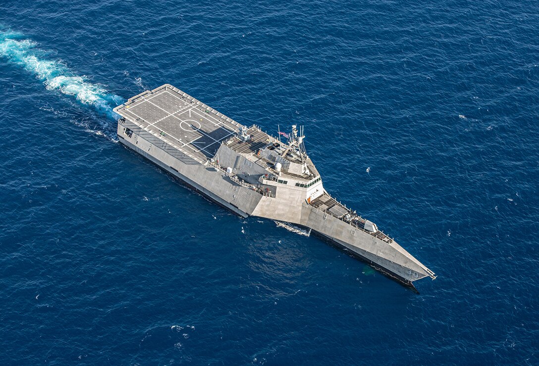 A Navy ship sails in open water.