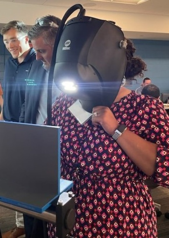 LaQuena Tolliver, Lead Logistics Management Specialist at TACOM, uses a virtual reality headset alongside LIFT representatives to simulate welding training at the TACOM-LIFT’s Industry 4.0 seminar series. (Adam Sikes)