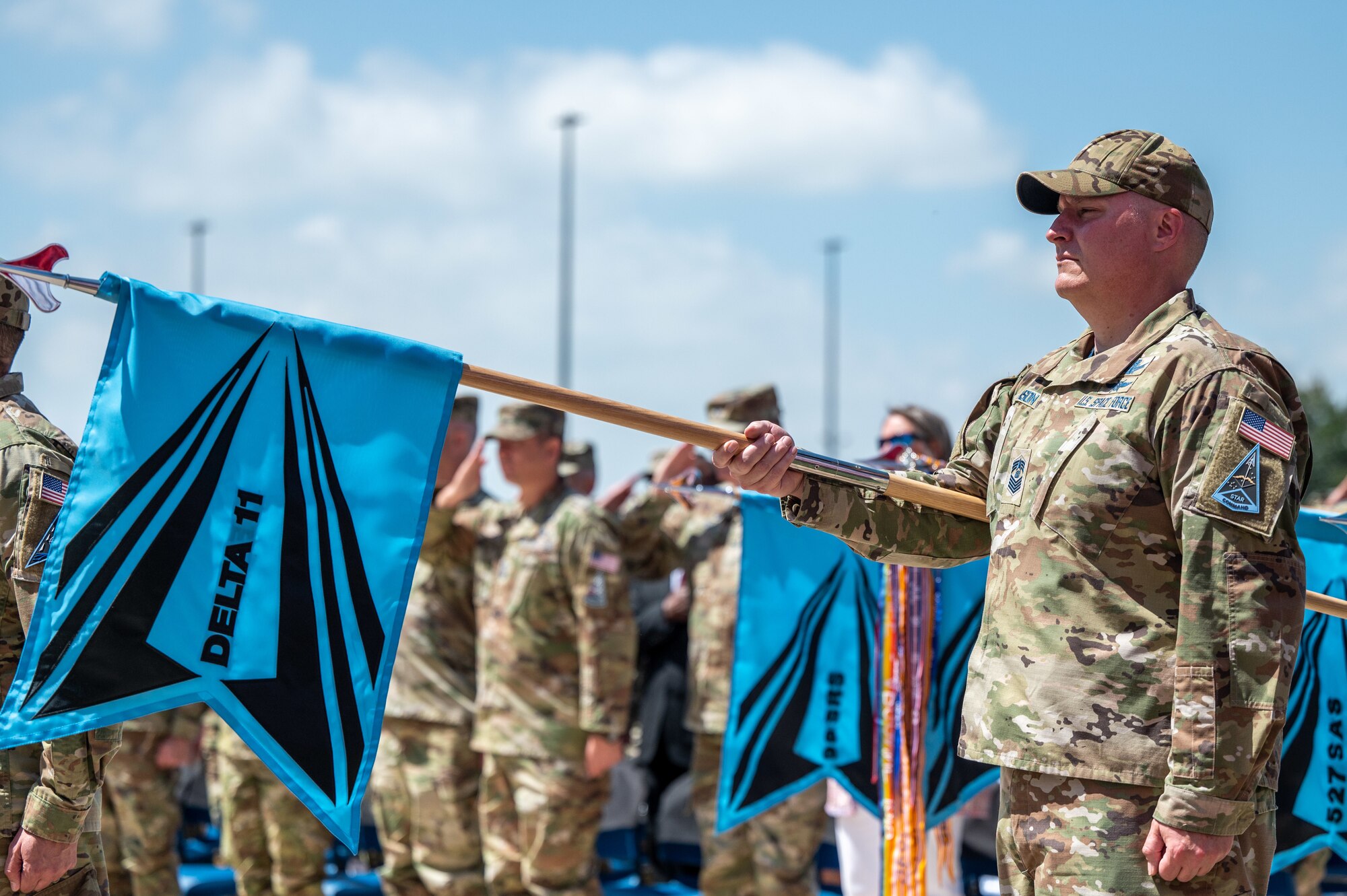 U.S. Space Force Chief Master Sgt. Matthew Robinson, Delta 11 senior enlisted leader, holds the Delta guidon during Delta 11’s change of command ceremony at Schriever Space Force Base, Colorado, July 7, 2023. Delta 11 is responsible for delivering realistic, threat-informed test and training resources to U.S. Space Force, joint, and coalition space operators via live, virtual, and constructive threat replication, leveraging the National Space Test and Training Complex across multiple space warfighting disciplines. (U.S. Space Force photo by Ethan Johnson)