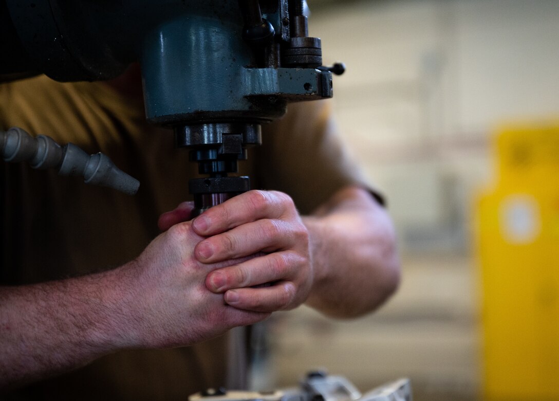 Metal Techs use a mill to repair F-22 machinery at JBLE