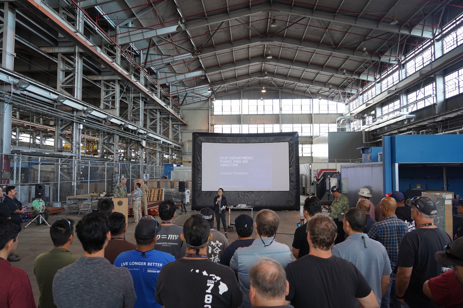 Shipyard Infrastructure Optimization Program Department Director Joanna Victorino, center, briefs shipyard personnel during a Town Hall held at the Structural Shop at Pearl Harbor Naval Shipyard.