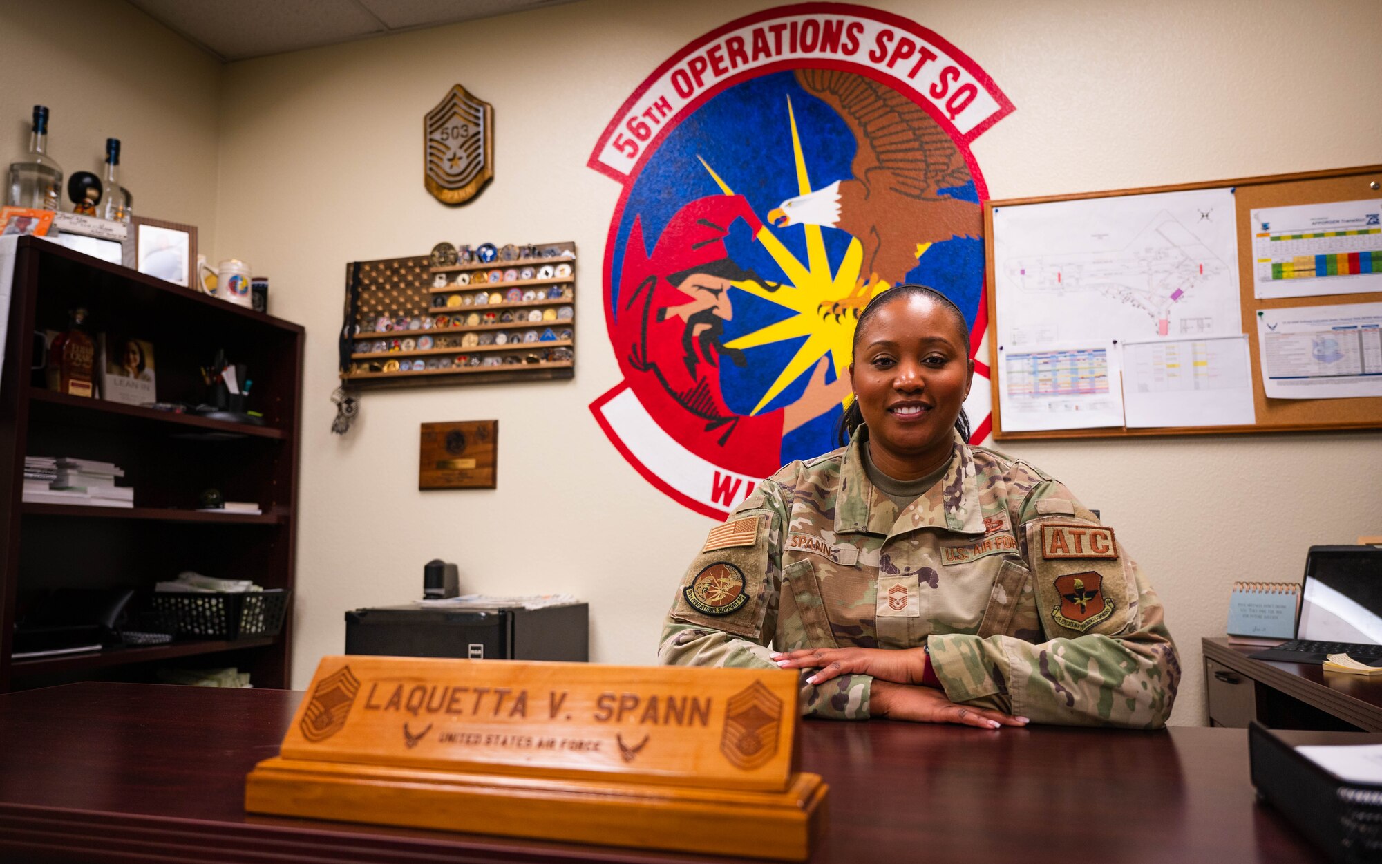 Chief Master Sgt. Laquetta Spann smiles for a photo at her desk