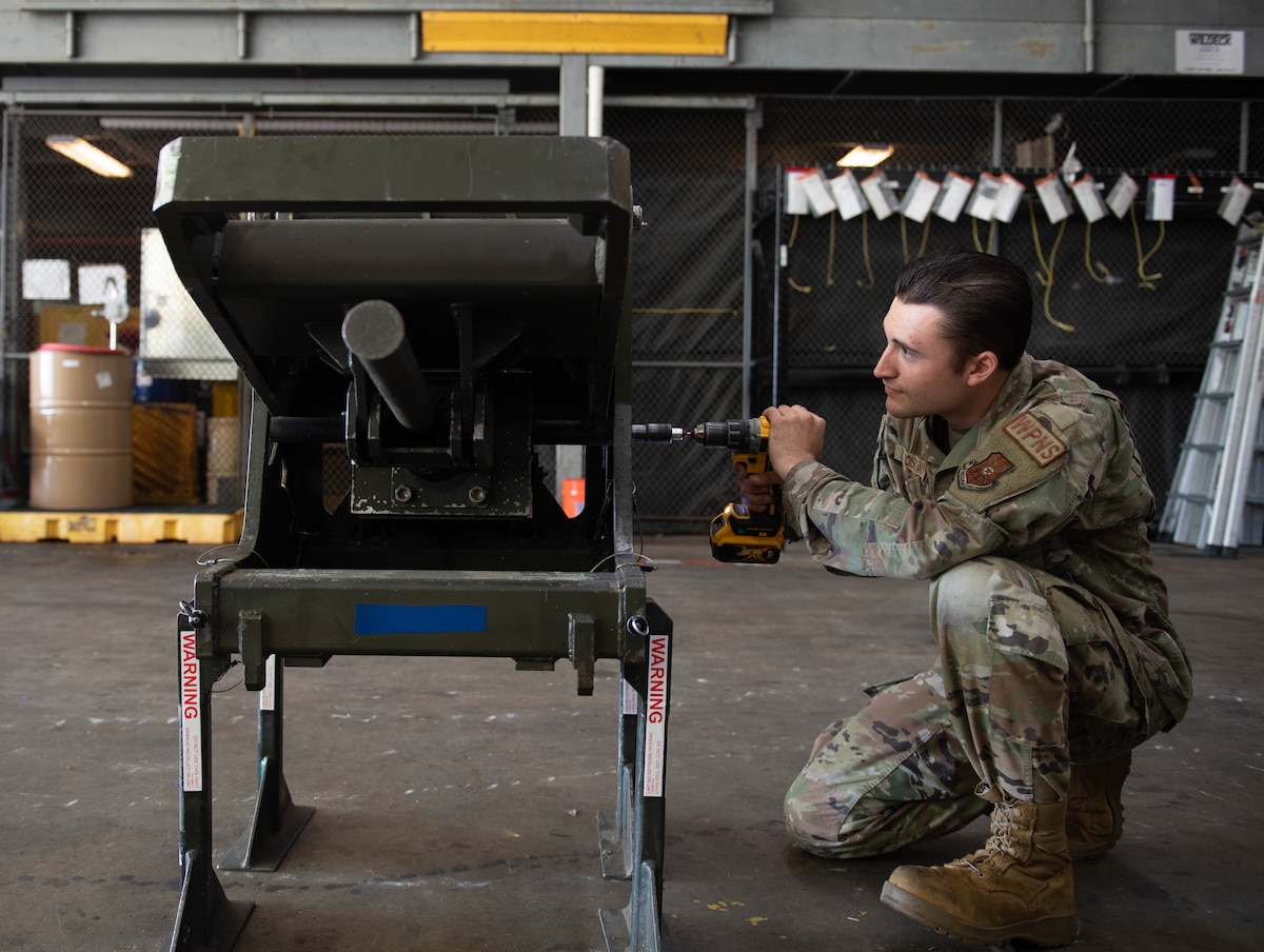 Senior Airman William Oskay, 96th Aircraft Maintenance Unit weapons load crew member, uses a power drill to test the capabilities of an ADU-468 as a part of the Project Arc program at Barksdale Air Force Base, Louisiana, Sept. 16, 2022. Project Arc is a program that consists of scientists and engineers from across the Air Force working with units to tackle problems and challenges using their knowledge to design new tools, widgets or rework a workflow. (U.S. Air Force photo by Staff Sgt. Christopher Tam)