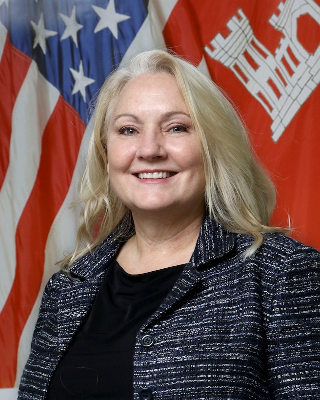 Stephanie Hall photo in front of U.S. and U.S. Army Corps of Engineers flags.