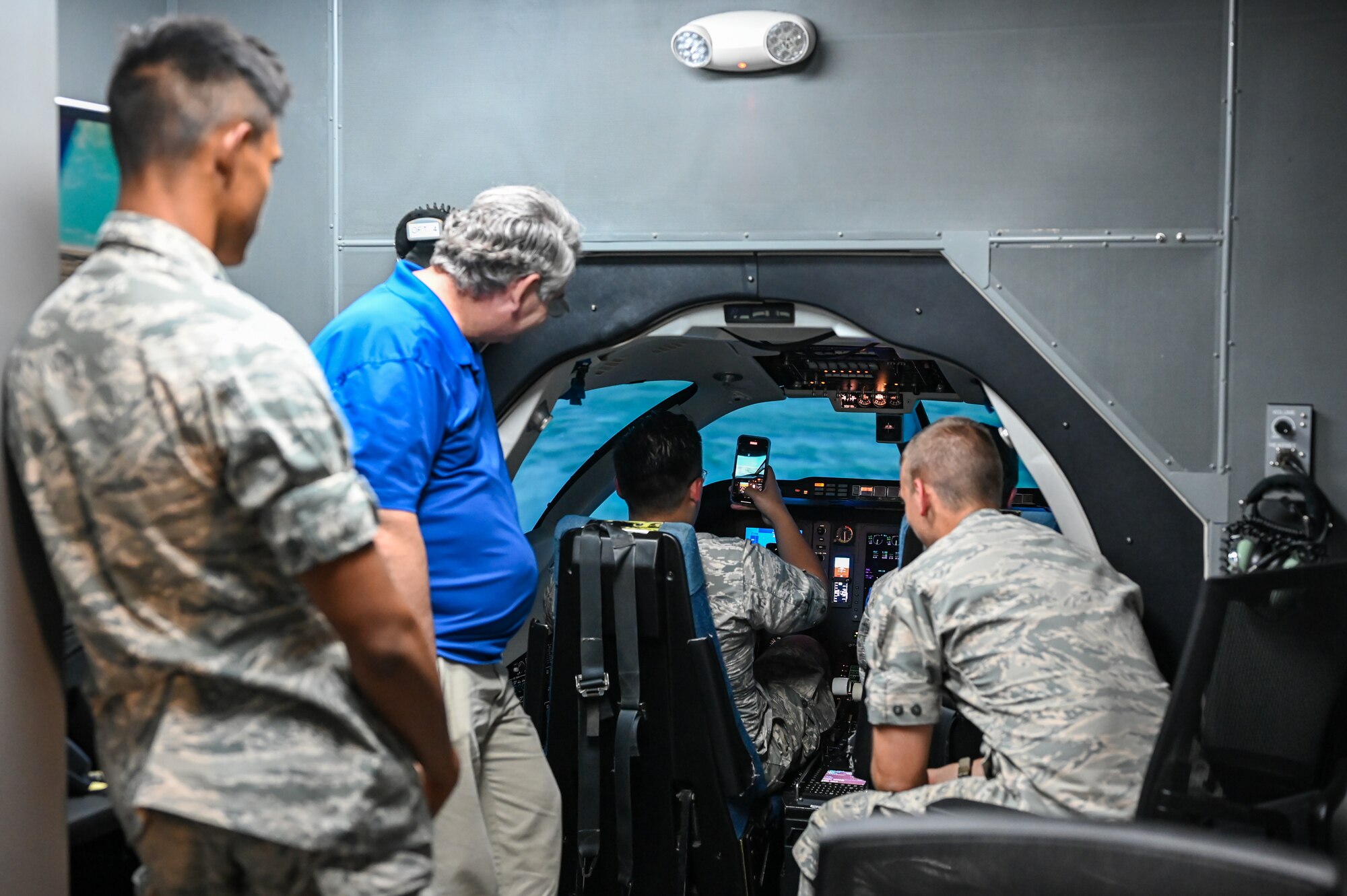 A Civil Air Patrol cadet takes a photo while in a T-1 Jayhawk simulation instructor at Laughlin Air Force Base, Texas, June 28, 2023.
