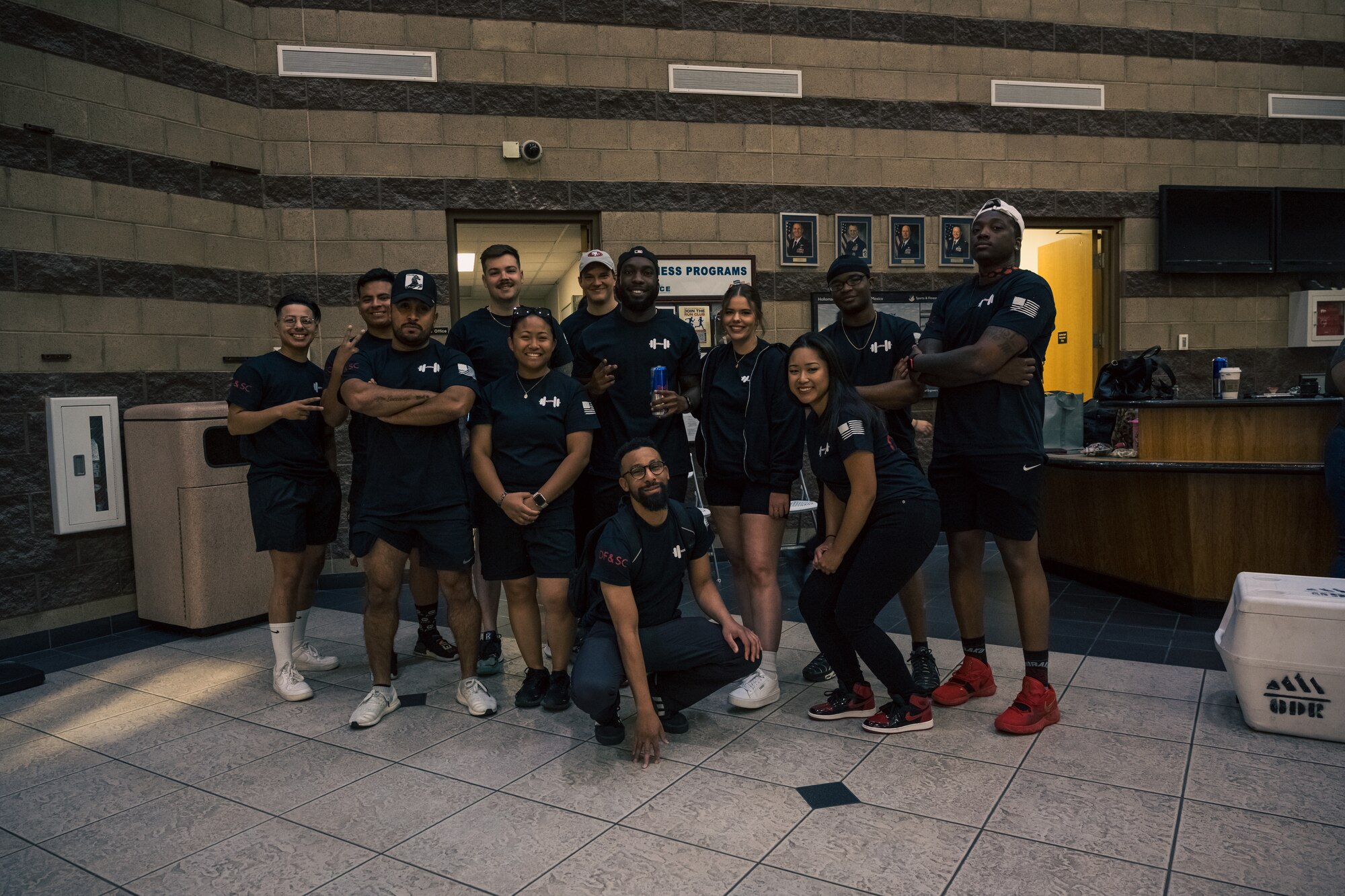 Airmen with the 49th Force Support Squadron pose for a photo before a weightlifting meet at Holloman Air Force Base, New Mexico, July 8, 2023. The 49th FSS hosts monthly events that encourage Airmen to excel in personal physical fitness, one of the four pillars of the comprehensive Airmen fitness. (U.S. Air Force by Senior Airman Antonio Salfran)