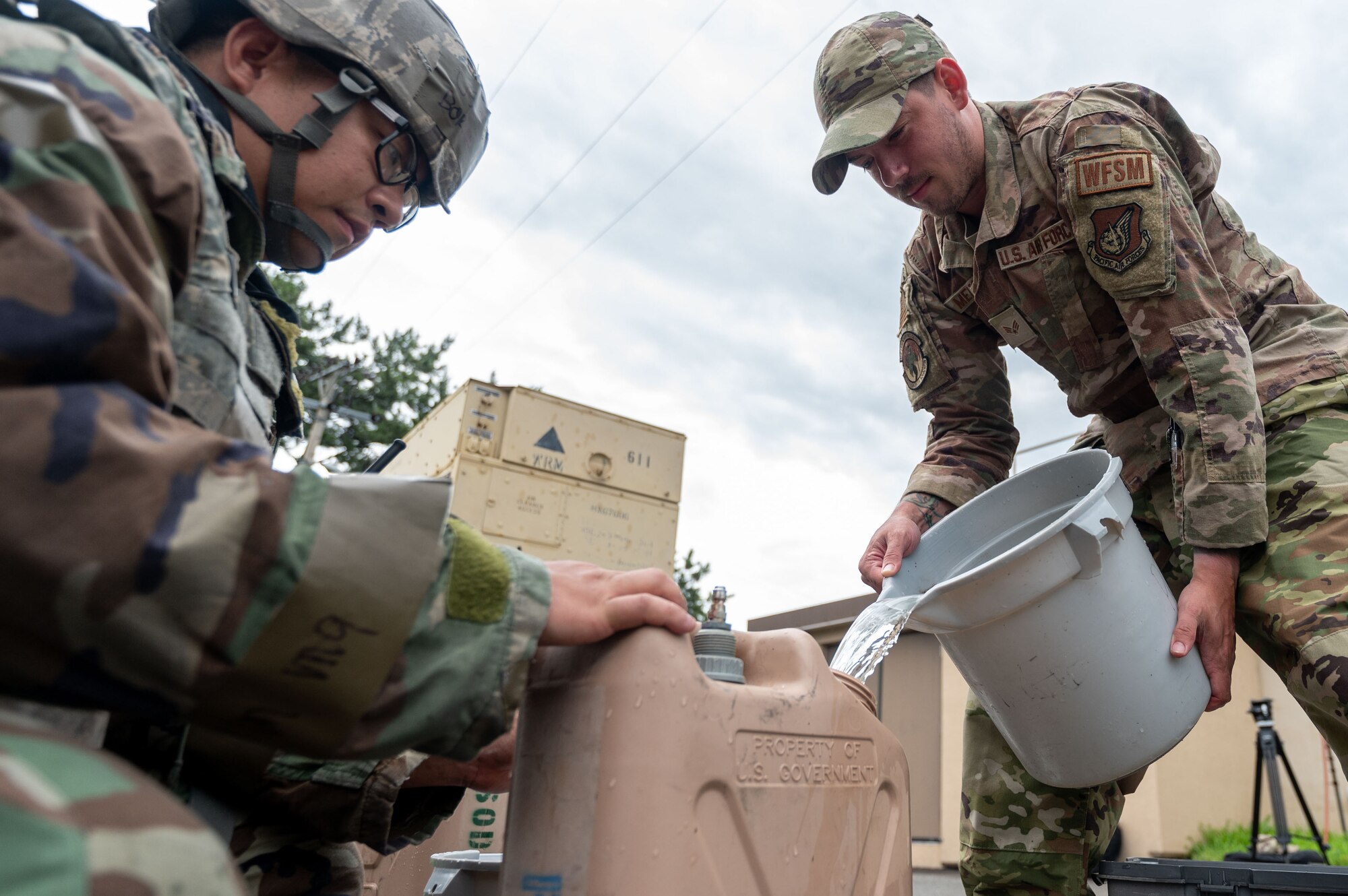 8th Civil Engineer Squadron water and fuels system maintenance journeyman, pours water into a canister containing a water purification solution