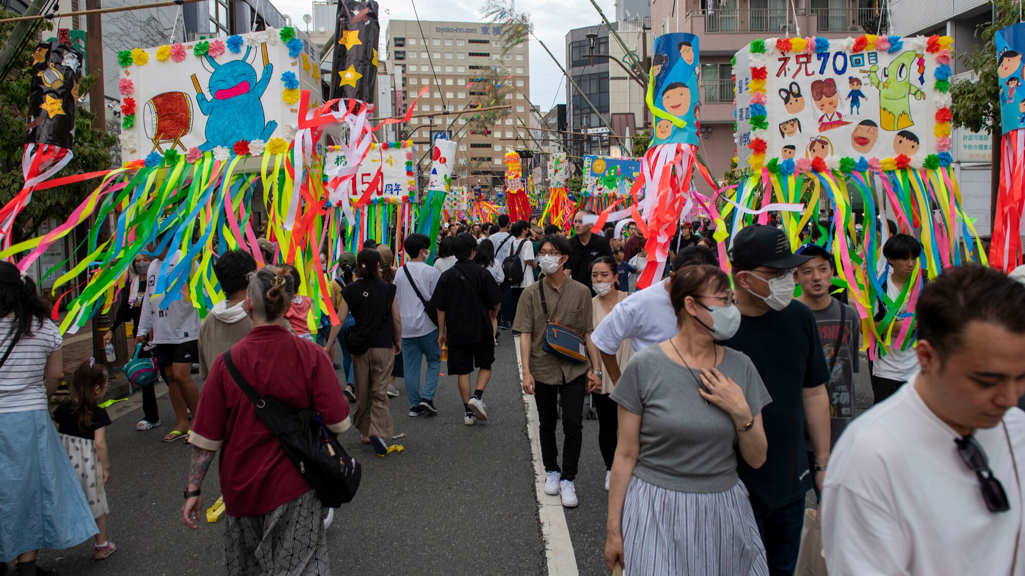 A street festooned with streamers and crowded with people