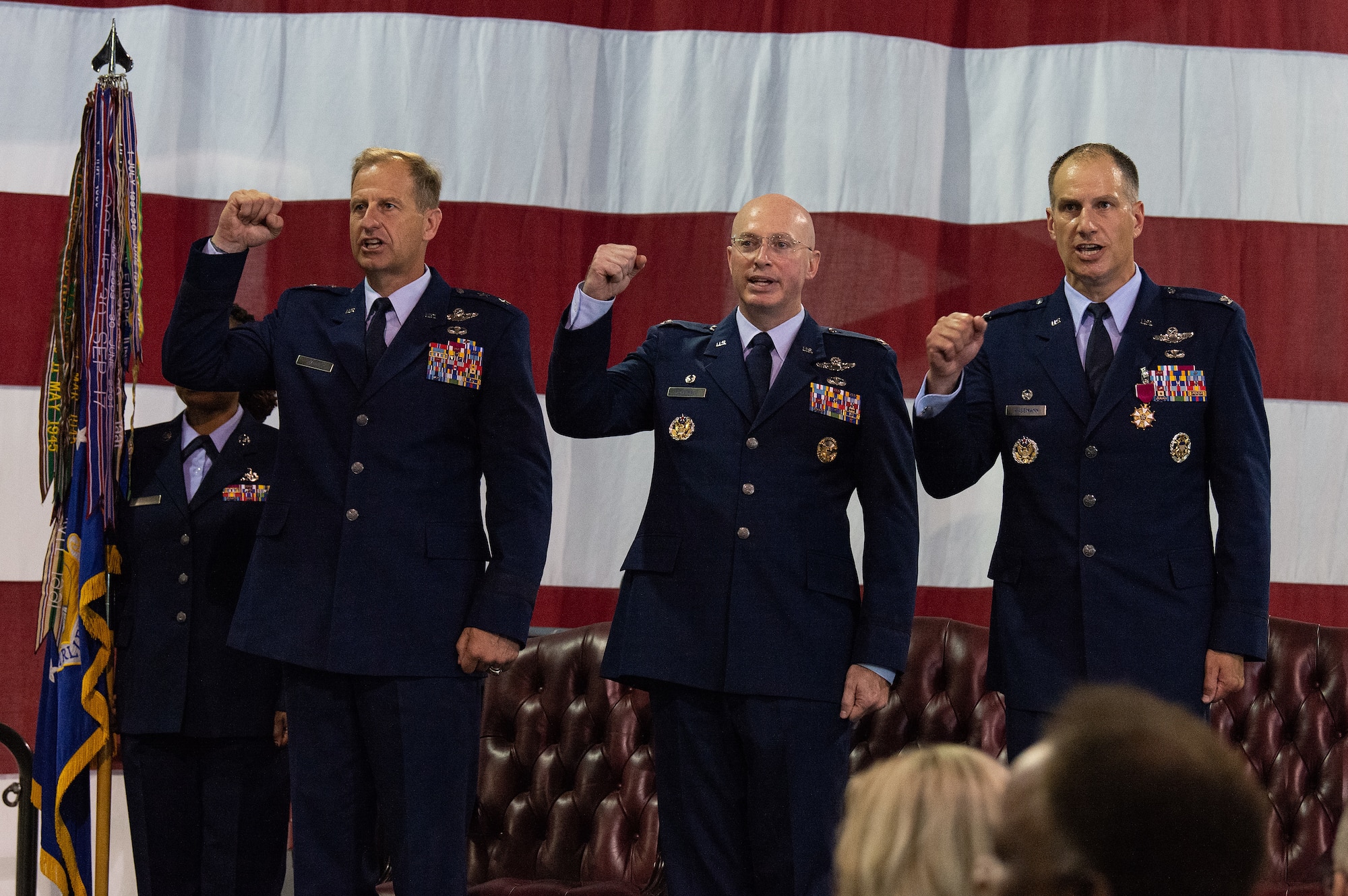 From left, Maj. Gen. Corey J. Martin, 18th Air Force commander, Col. William C. McDonald, 436th Airlift Wing commander, and Col. Matthew S. Husemann, outgoing 436th AW commander, sing the Air Force song during the 436th AW Change of Command ceremony at Dover Air Force Base, Delaware, July 7, 2023. Husemann relinquished command to McDonald in a ceremony attended by family, friends, distinguished visitors, local civic leaders and members of Team Dover. (U.S. Air Force photo by Roland Balik)