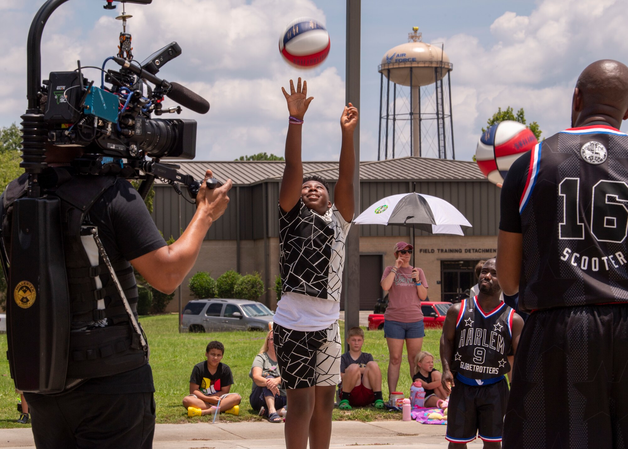 A young participant shoots a basketball during a Harlem Globetrotters visit at Moody Air Force Base, Georgia, July 6, 2023. The Harlem Globetrotters regularly support military communities with visits to installations all around the world. (U.S. Air Force photo by Airman 1st Class Leonid Soubbotine)