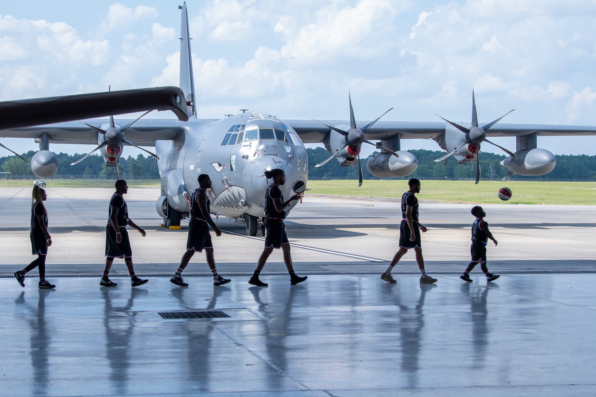 Members of the Harlem Globetrotters walk in front of an HC-130J Combat King II during the team’s visit to Moody Air Force Base, Georgia, July 6, 2023. This HC-130J was named “Whale Shark” and sports the distinct Flying Tiger teeth paint job. (U.S. Air Force photo by Airman 1st Class Leonid Soubbotine)