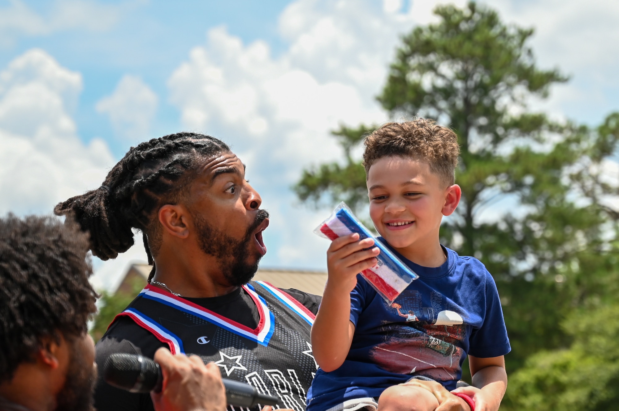 Donte “Hammer” Harrison celebrates a young participant after receiving a trophy during the Harlem Globetrotters visit to Moody Air Force Base, Georgia, July 6, 2023. Young attendees played several games and learned tricks with the famous team. (U.S. Air Force photo by Senior Airman Stacey Thornburg)