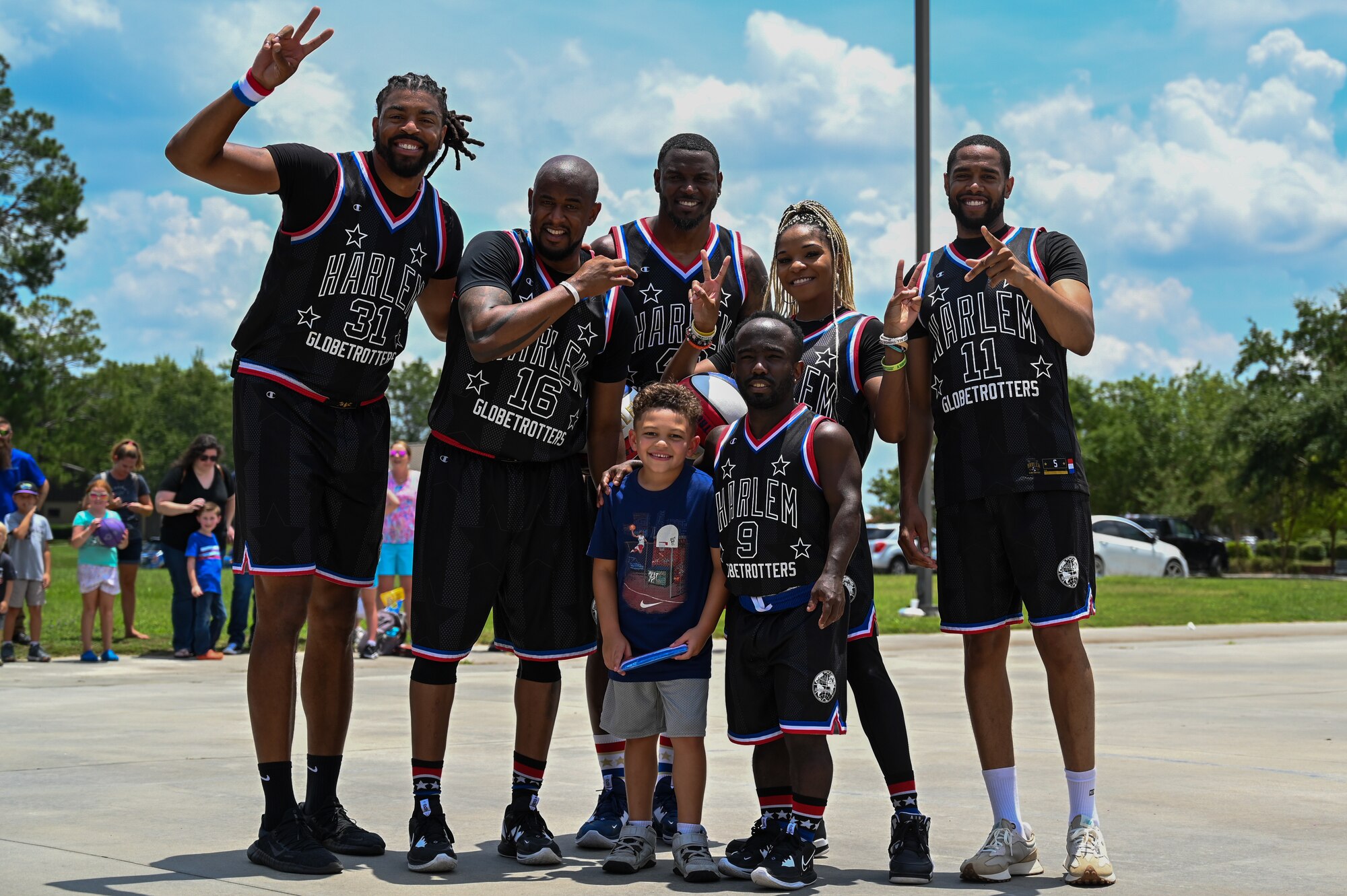 A young participant poses with members of the Harlem Globetrotters during their visit to Moody Air Force Base, Georgia, July 6, 2023. The Harlem Globetrotters frequently engage in shows on military bases all over the U.S. and overseas. (U.S. Air Force photo by Senior Airman Stacey Thornburg)