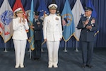 three military general officers stand on a stage