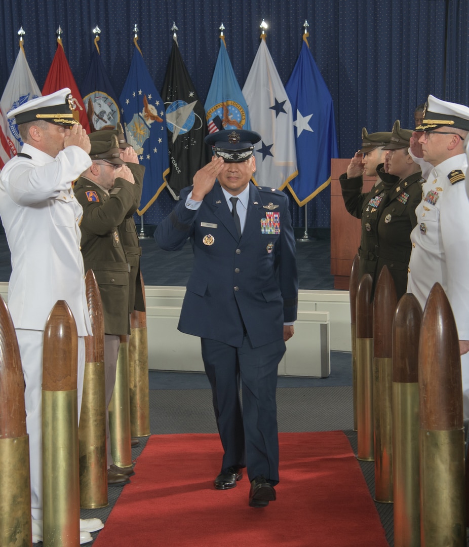 a military general officer walks down an aisle while saluting