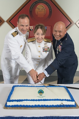 Three military general officers in uniform cut a cake