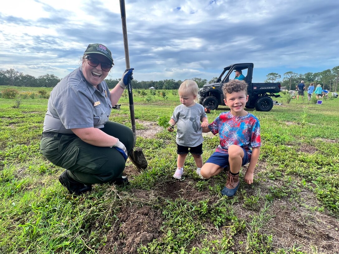 Jacksonville District Park Ranger, Megan Parsons (right) helps a volunteer to dig and plant a tree.  Volunteers will plant nearly 9,000 native pollinator wildflowers and grasses at the W.P. Franklin Recreation Area during Pollinator Week on June 24, in the second phase of plantings to reforest an 8.5 acre open field as part of the Engineering with Nature Program. (USACE photo by Mark Rankin)