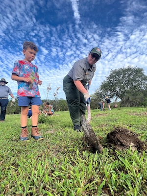 Jacksonville District Park Ranger, Megan Parsons (right) helps a volunteer to dig and plant a tree.  Volunteers will plant nearly 9,000 native pollinator wildflowers and grasses at the W.P. Franklin Recreation Area during Pollinator Week on June 24, in the second phase of plantings to reforest an 8.5 acre open field as part of the Engineering with Nature Program. (USACE photo by Mark Rankin)