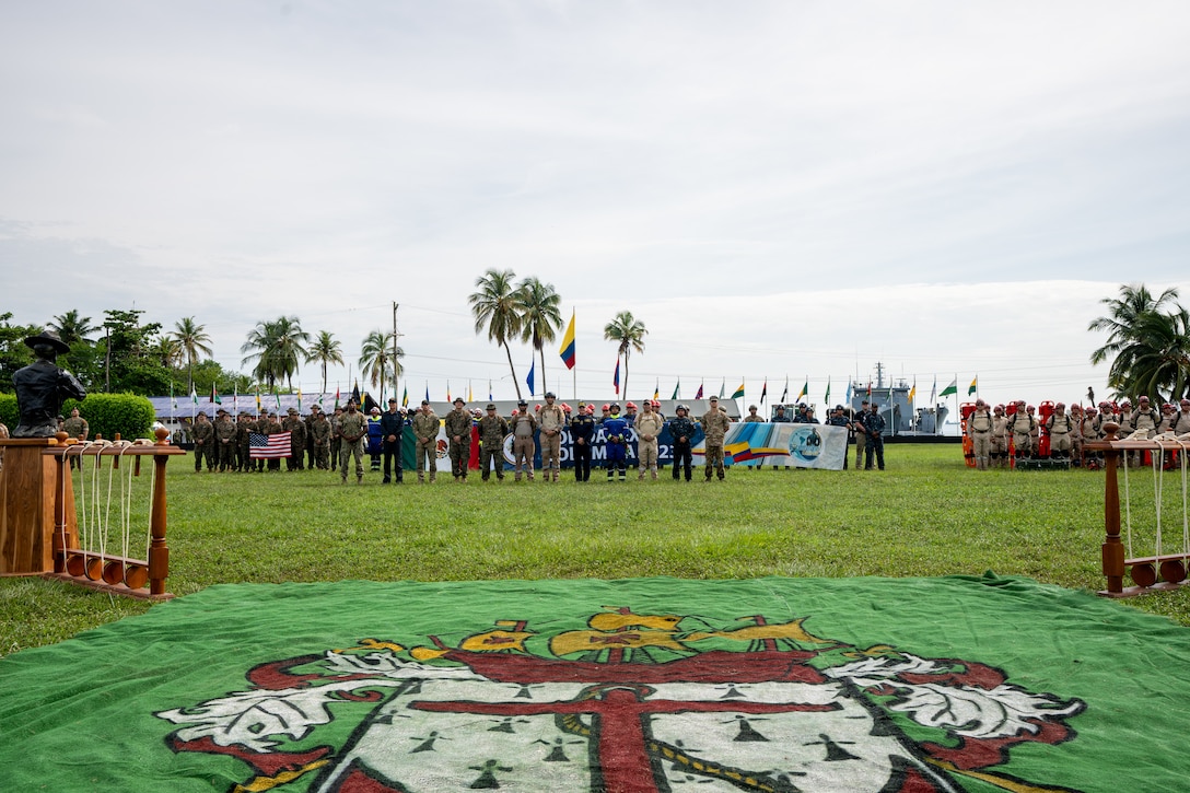 U.S. Navy Sailors from Combat Logistics Battalion 8, Combat Logistics Regiment 27, 2nd Marine Logistics Group, in support of Special Purpose Marine Air-Ground Task Force UNITAS LXIV, pose alongside members of 8 different foreign nations for a group photo during the opening ceremony of exercise SOLIDAREX, aboard Escuela de Formación de Infantería Marina Coveñas in Coveñas, Colombia, July 9, 2023. Twelve ships from eight countries participated in the humanitarian assistance exercise designed to train a multinational task force to respond to large-scale emergencies. This was the largest exercise of this kind in the Caribbean. (U.S. Marine Corps photo by Sgt. Juan Carpanzano)