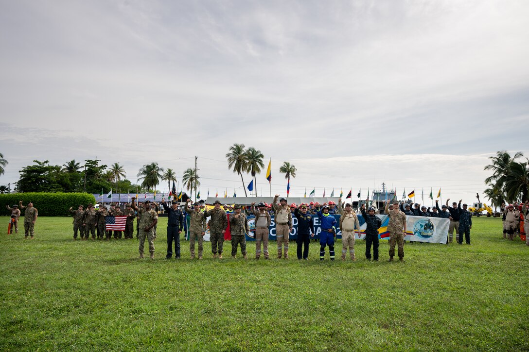 U.S. Navy Sailors from Combat Logistics Battalion 8, Combat Logistics Regiment 27, 2nd Marine Logistics Group, in support of Special Purpose Marine Air-Ground Task Force UNITAS LXIV, pose alongside members of 8 different foreign nations for a group photo during the opening ceremony of exercise SOLIDAREX, aboard Escuela de Formación de Infantería Marina Coveñas in Coveñas, Colombia, July 9, 2023. Twelve ships from eight countries participated in the humanitarian assistance exercise designed to train a multinational task force to respond to large-scale emergencies. This was the largest exercise of this kind in the Caribbean. (U.S. Marine Corps photo by Sgt. Juan Carpanzano)