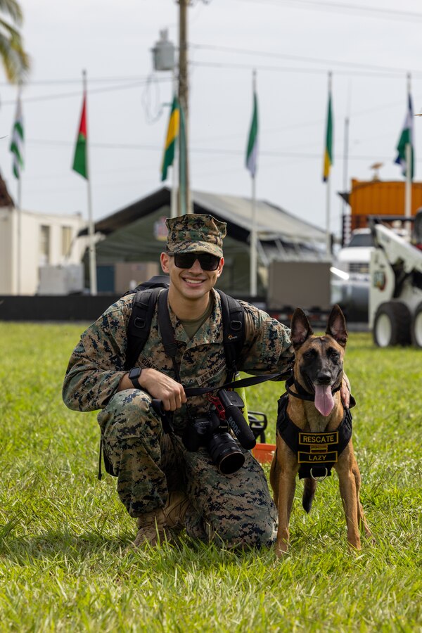 U.S. Marine Corps Cpl. Jonathan Gonzalez, a combat videographer attached to U.S. Marine Corps Forces, South for UNITAS LXIV, poses for a photo with a Colombian Marine Corps military working dog during the opening ceremony of exercise SOLIDAREX, aboard Escuela de Formación de Infantería Marina Coveñas in Coveñas, Colombia, July 9, 2023. Twelve ships from eight countries participated in the humanitarian assistance exercise designed to train a multinational task force to respond to large-scale emergencies. This was the largest exercise of this kind in the Caribbean. (U.S. Marine Corps photo by Sgt. Juan Carpanzano)