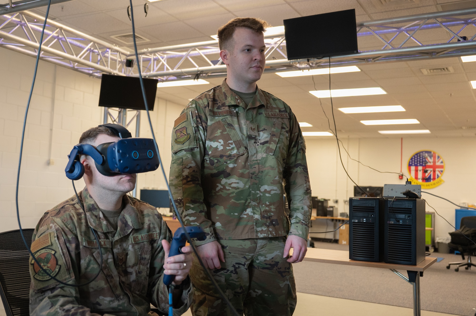 U.S. Air Force Tech. Sgt. Jacob Womack, left, 100th Maintenance Group aerospace propulsion craftsman and NCO in charge of development, and Staff Sgt. Jeremiah Havener, right, 100th MXG aircraft electrical and environmental systems craftsman and NCO in charge of virtual reality, uses a virtual reality system to complete a KC-135 Stratotanker aircraft technical order at Royal Air Force Mildenhall, England June 28, 2023.