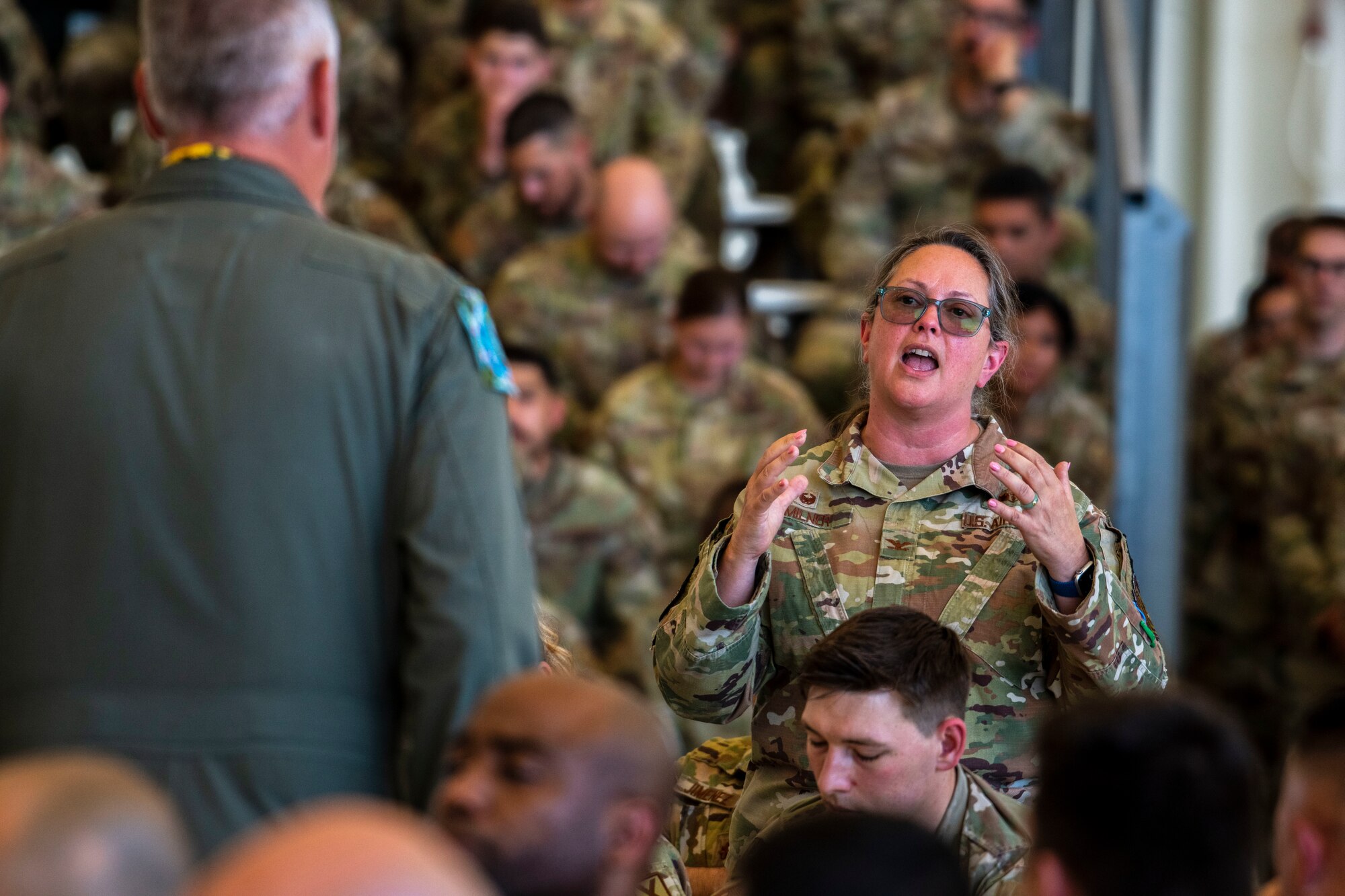 An Airman speaks in front of a a lot of other Airmen.