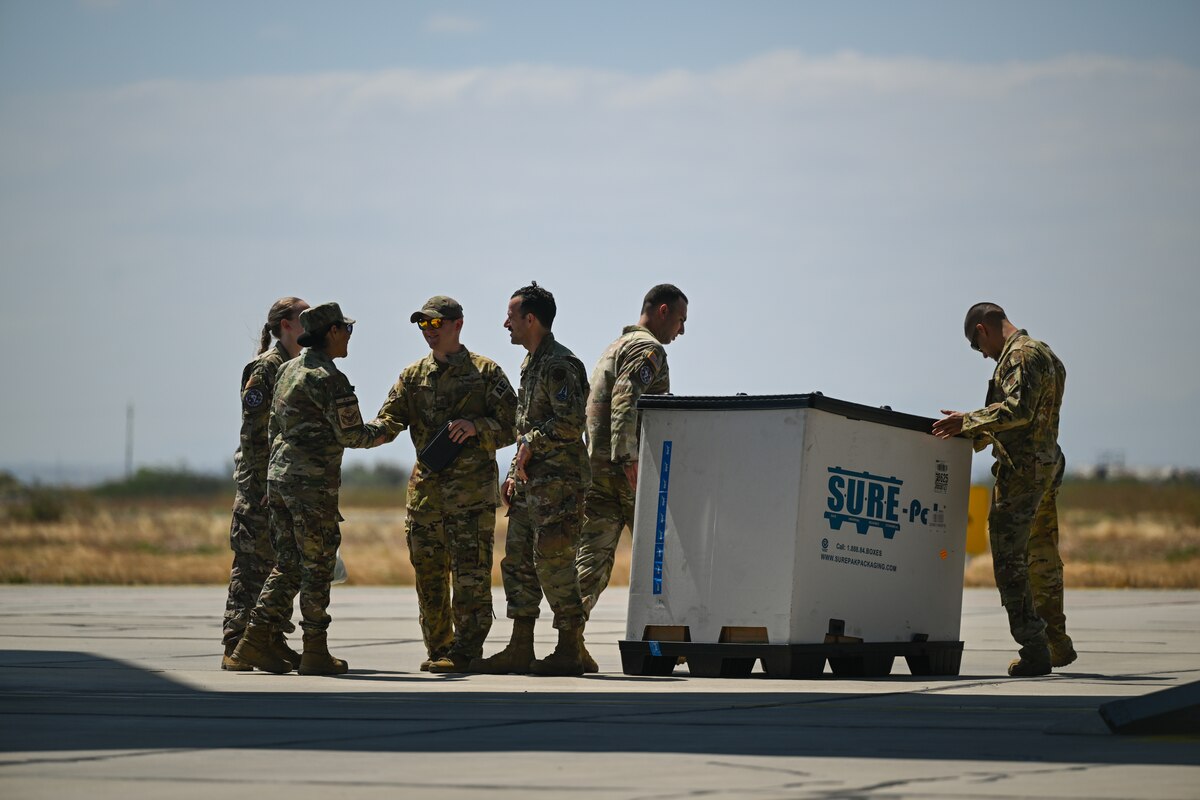 Photo of people standing around a box of medical supplies.