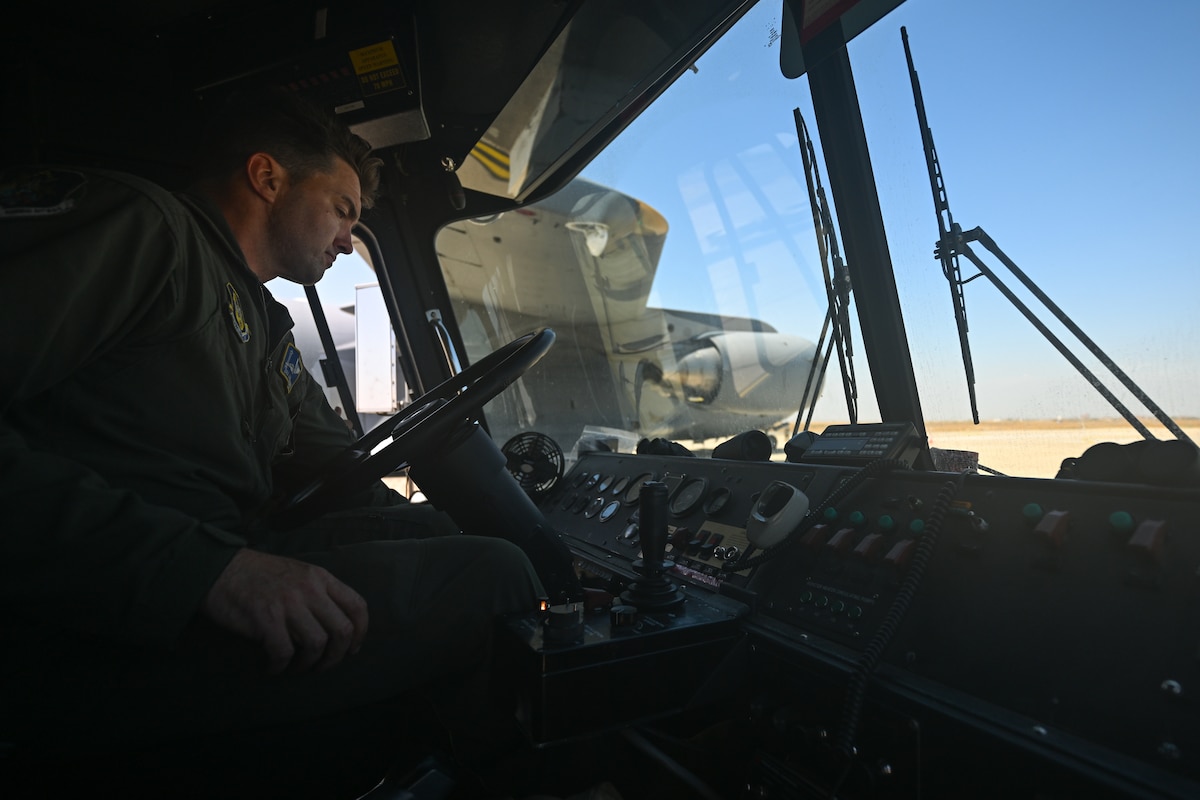 Photo of individual behind the wheel of a firetruck.