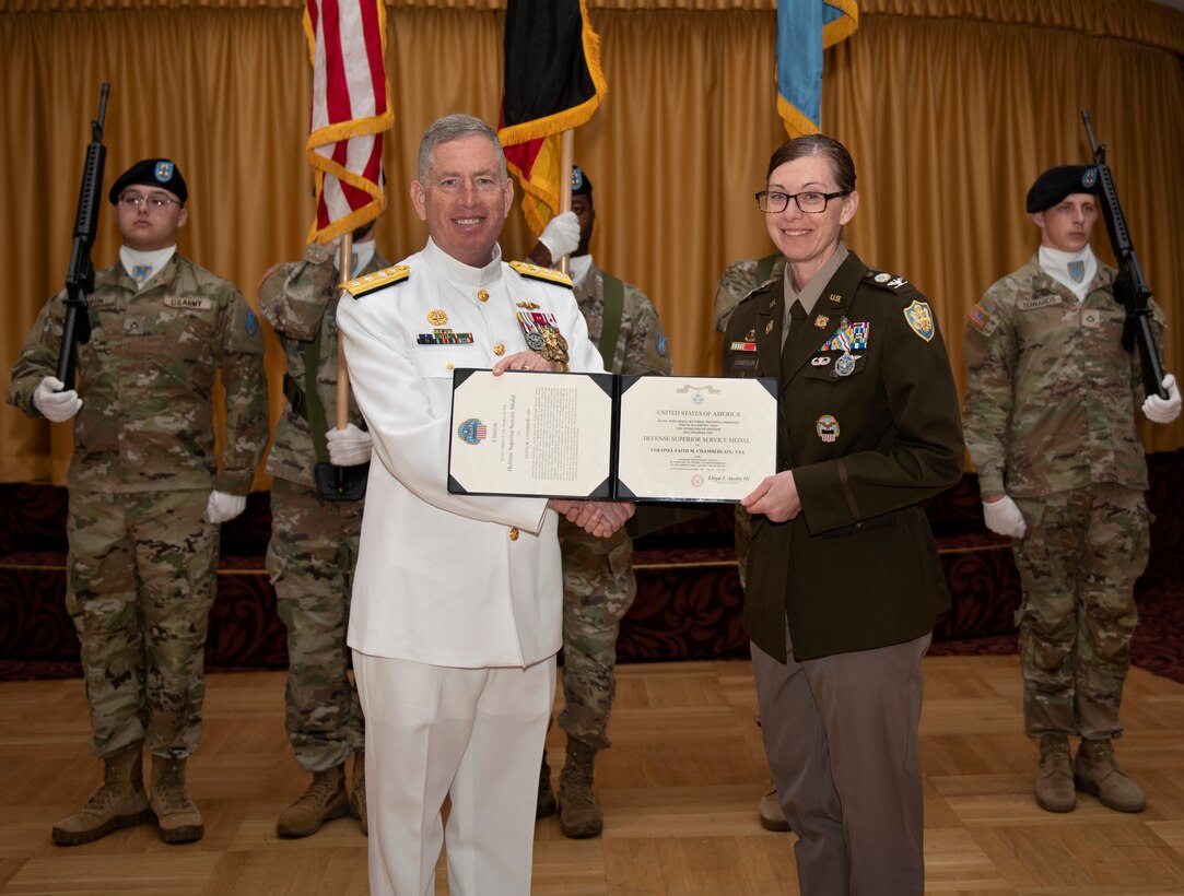 Two military officers pose with an award.