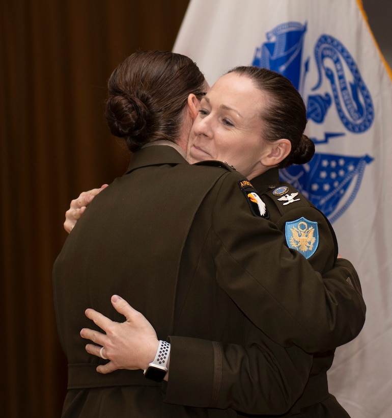 Two Army colonels hug.