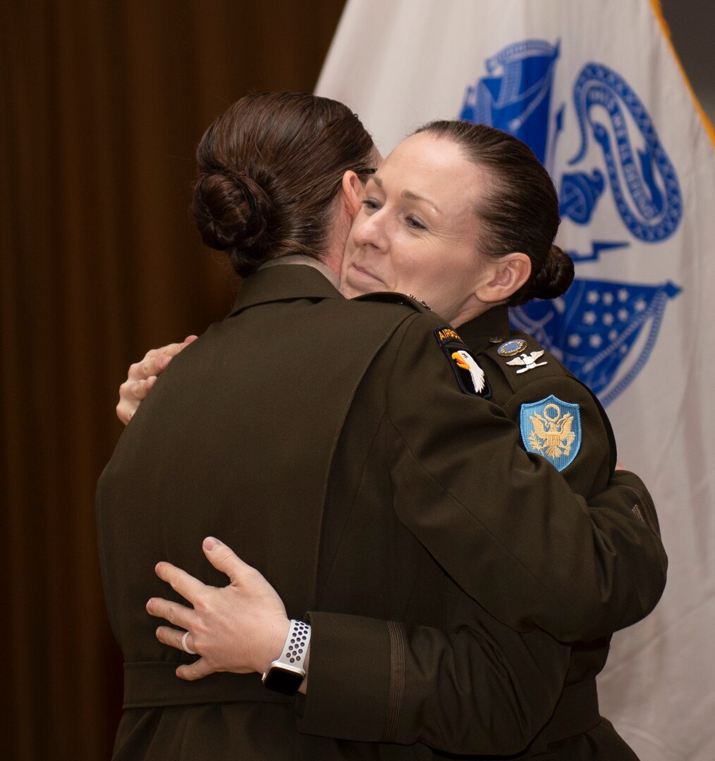 Two Army colonels hug.