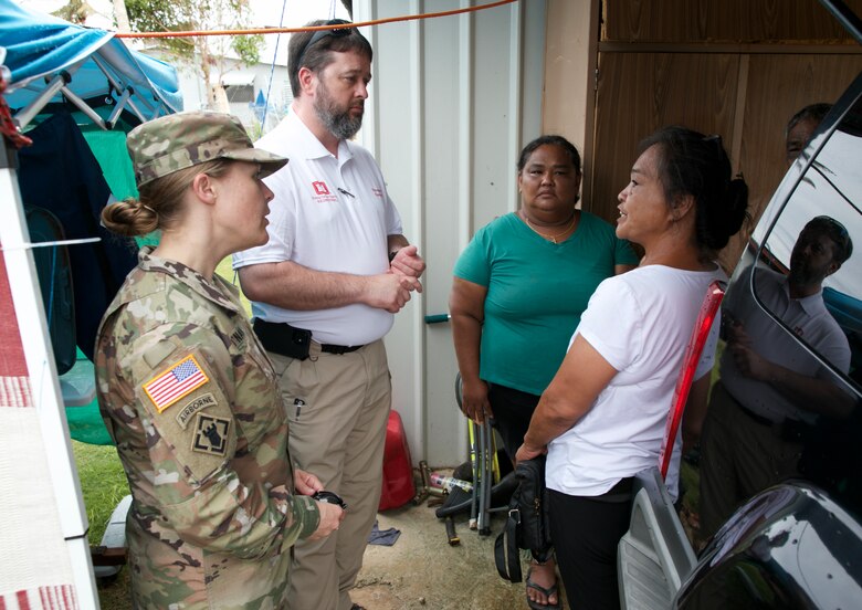 Lt. Col. Chelsey O’Nan, senior USACE representative on Guam, and USACE temporary roofing action officer Travis Wilson speak with Guam residents who received the 100th temporary, emergency roof as part of the Roofing Installation Support Emergency Utilization Program (RISEUP), in Mangilao, Guam, June 27. The U.S. Department of Defense and USACE, in coordination with the Federal Emergency Management Agency and the U.S. Territory of Guam, launched RISEUP to help temporarily repair metal roofs damaged by Typhoon Mawar which made land fall May 24.