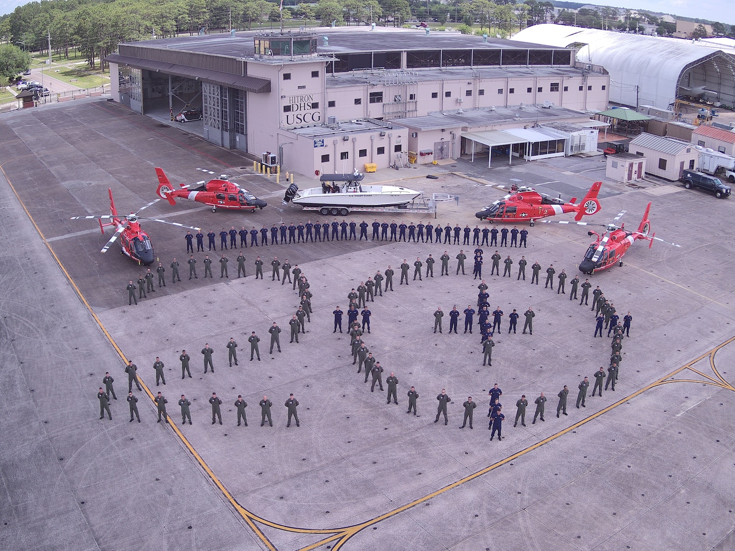 The crew of Helicopter Interdiction Tactical Squadron poses for a photo in front of unit assets, Aug. 16, 2019, Jacksonville, Florida. This photo commemorates the unit’s 20th year. (U.S. Coast Guard photo courtesy of HITRON)
