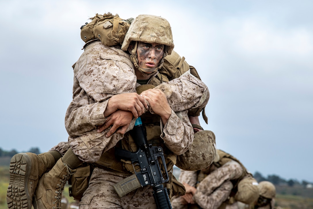 U.S. Marine Corps recruit Landen Frettwell, with Mike Company, 3rd Recruit Training Battalion, fireman carries another recreuit during the Crucible on Marine Corps Base Camp Pendleton, Calif., July 10, 2023. The Crucible is a 54-hour exercise where recruits apply the knowledge they have learned throughout recruit training, to earn the title of United States Marines. Frettwell is a native of Brownsboro, Texas and enlisted in the Marine Corps to create a better life for himself. (U.S. Marine Corps photo by Sgt. Guyette)