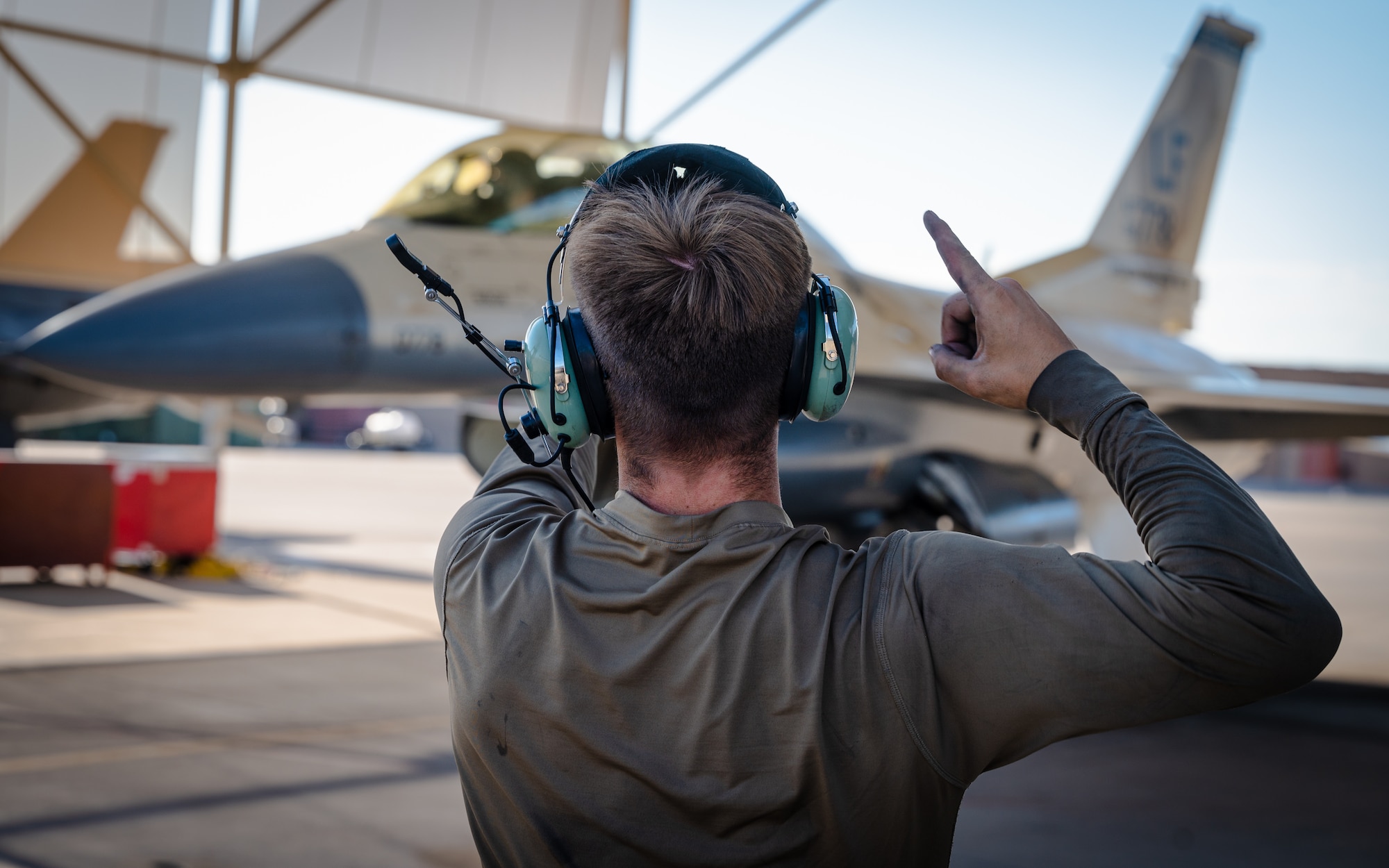 Airman 1st Class Keilani Durfey, 309th Fighter Squadron crew chief, signals to Maj. Saul Sharafinski, 309th FS F-16 Fighting Falcon pilot, before takeoff, July 10, 2023, at Luke Air Force Base, Arizona.