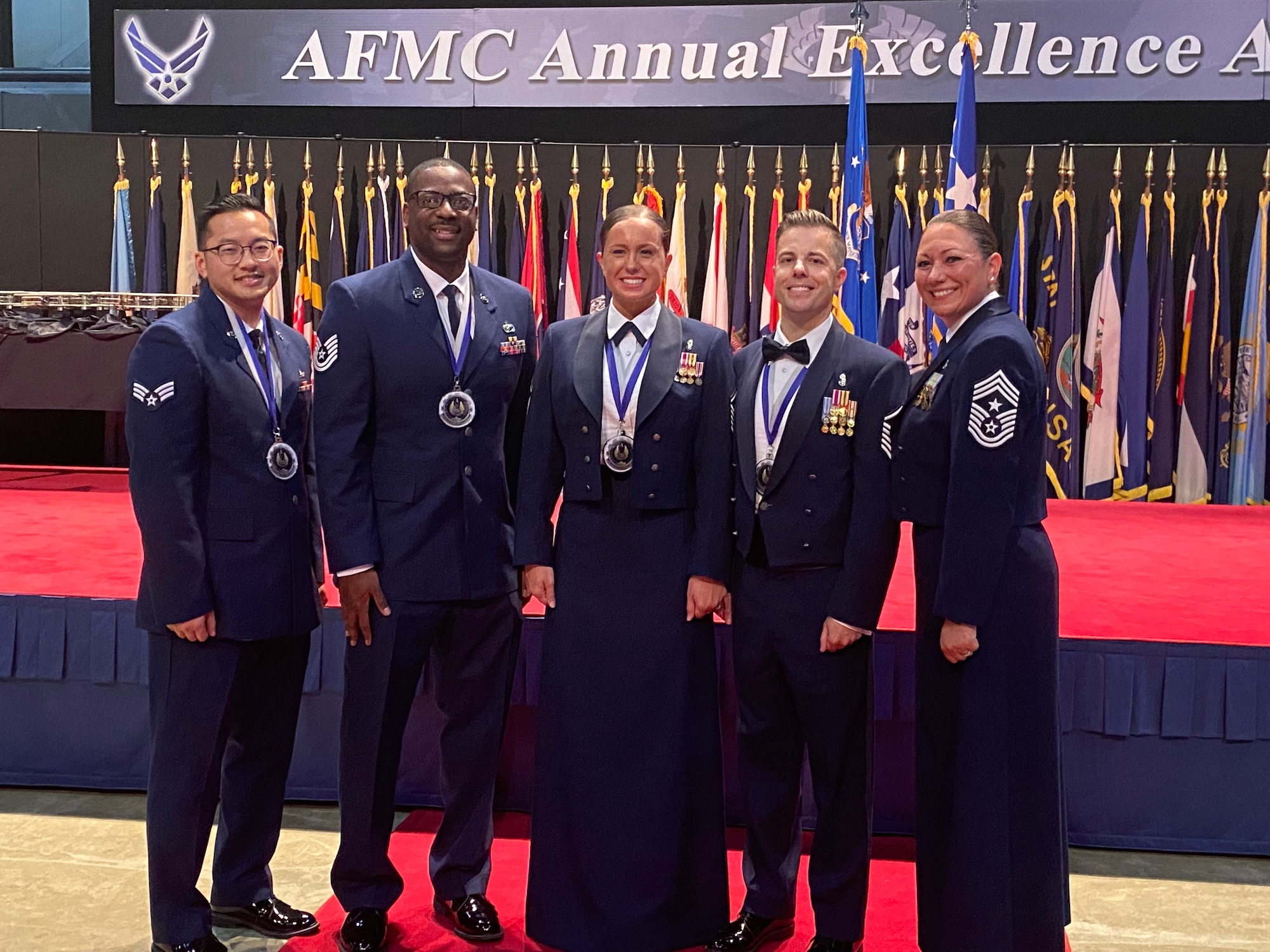 Chief Master Sgt. Sevin Balkuvvar poses for a photo with award winners at the Air Force Material Command Annual Excellence Award Ceremony.