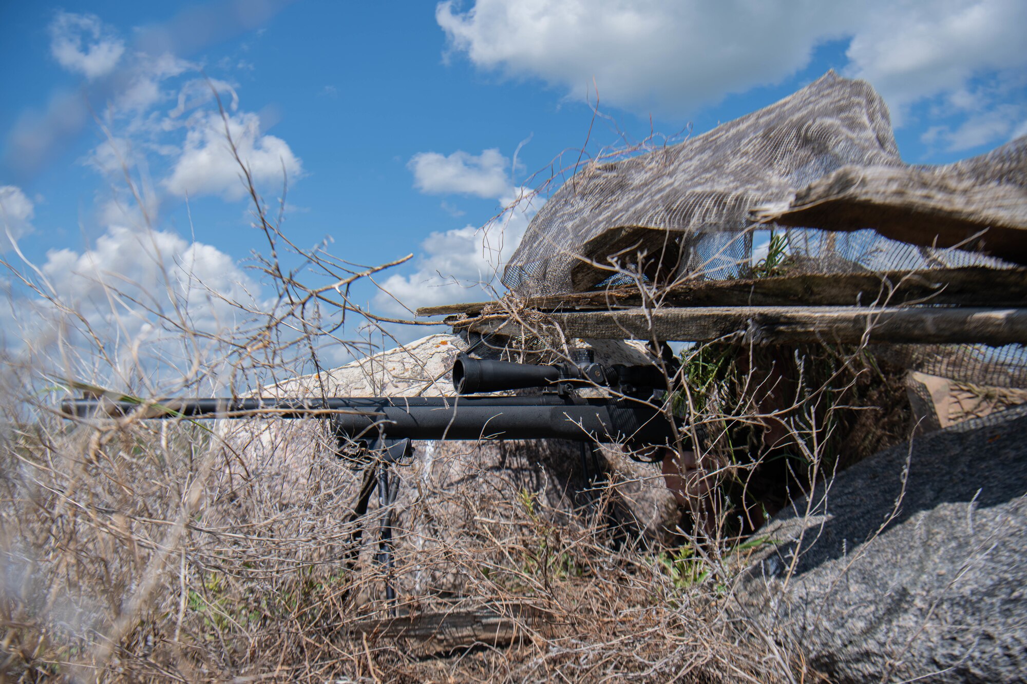 Tech. Sgt. Benjamin Lingenfelter, 219th Security Forces Squadron defender, fires blanks from an M24 rifle in Mountrail County, North Dakota, July 7, 2023. Lingenfelter acted as an enemy sniper during a recapture and recovery exercise to provide an additional challenge to security forces. (U.S. Air Force photo by Airman 1st Class Kyle Wilson)