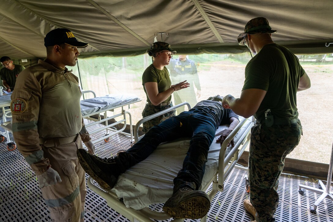 U.S. Navy Sailors from Combat Logistics Battalion 8, Combat Logistics Regiment 27, 2nd Marine Logistics Group, in support of Special Purpose Marine Air-Ground Task Force UNITAS LXIV, triage a patient during Multinational Operation Solidarex 2023 aboard Escuela de Formación de Infantería Marina Coveñas in Coveñas, Colombia, July 9, 2023. Twelve ships from eight countries participated in the humanitarian assistance exercise designed to train a multinational task force to respond to large-scale emergencies. This was the largest exercise of this kind in the Caribbean. (U.S. Marine Corps photo by Sgt. Juan Carpanzano)