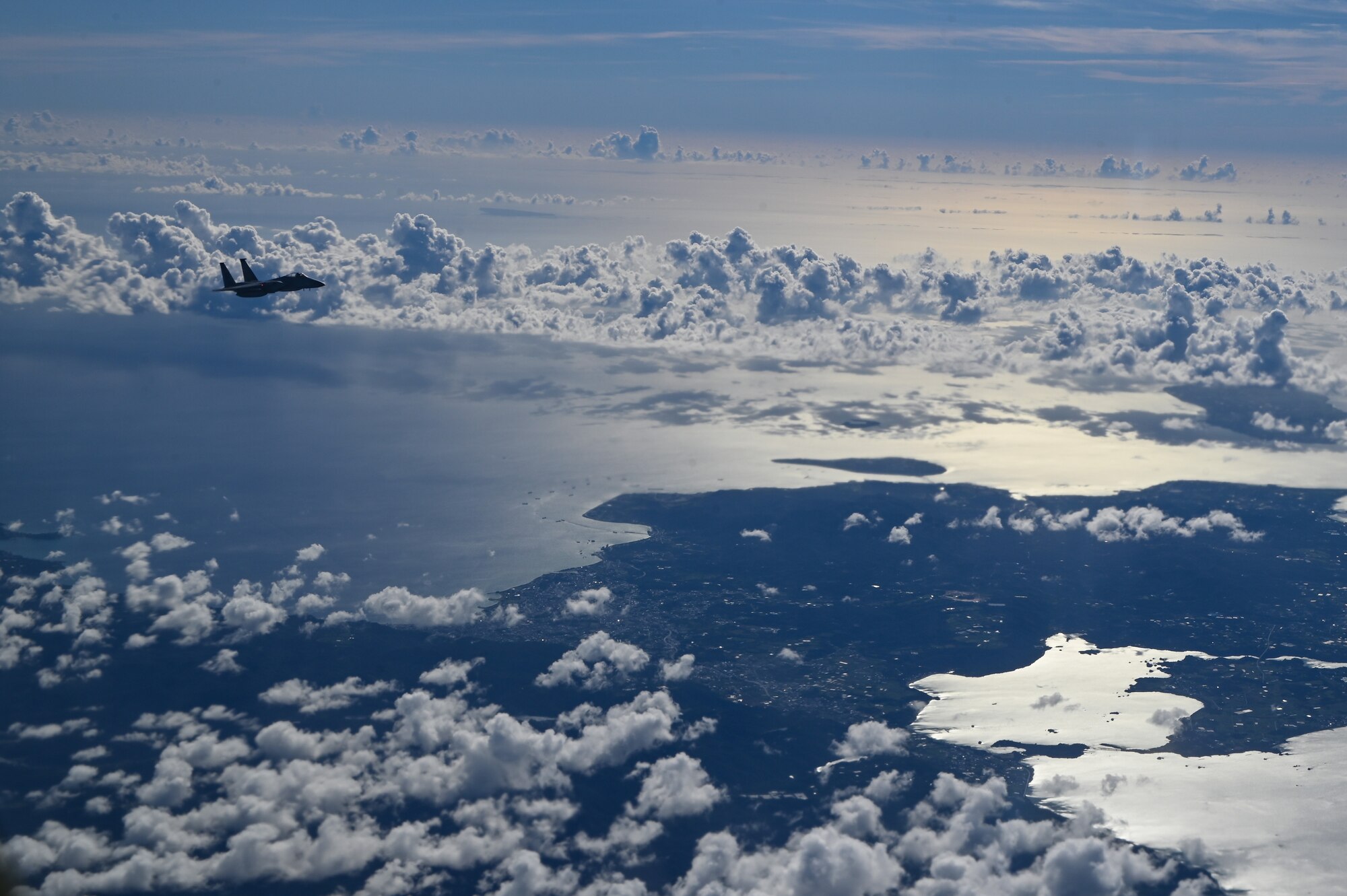 An aircraft flies over land.