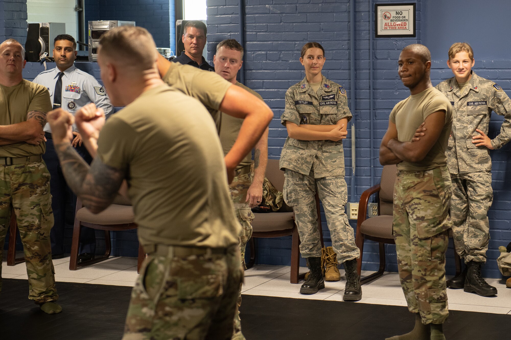 Cadets observe two Airmen practicing combatives training.
