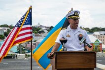 Capt. Nakia Cooper stands in front of the National Ensign and The Bahamian flag
