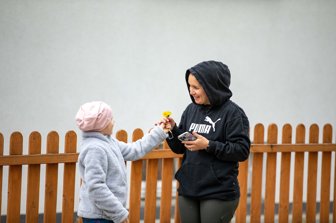 A child gives a soldier flowers.