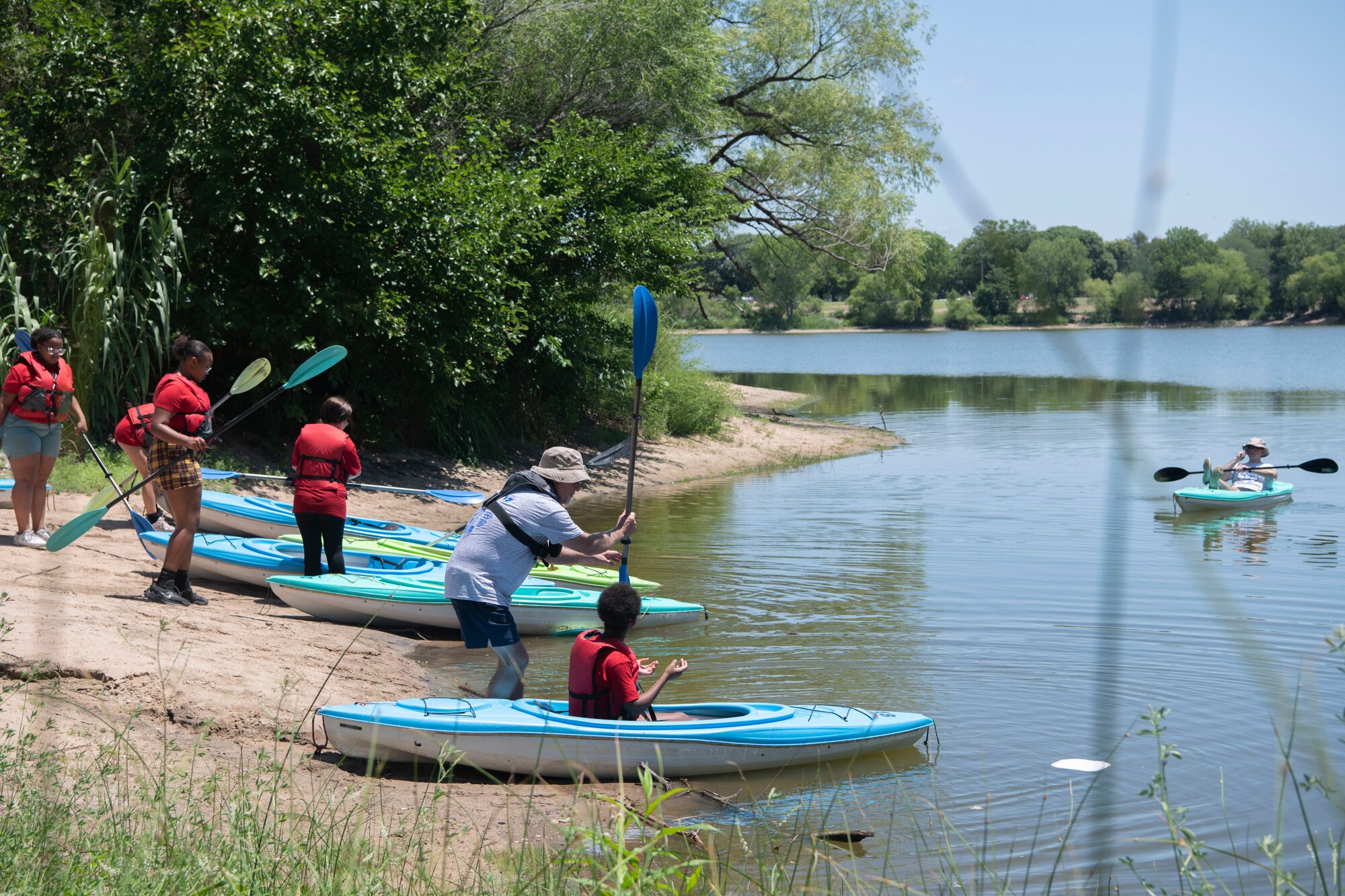 Volunteers at L.A.W Camp teach campers how to kayak at O.J Watson Park, Wichita, Kansas July 11, 2023. Camp activities included kayaking, fishing, golf, paddleboats, corn hole, K-9 demonstrations, volleyball, a heavy rescue demo by the county fire department, and group discussions with Wichita Police Department officers about gangs, peer pressure, and de-escalation. (U.S. Air Force Photo by Airman 1st Class Gavin Hameed)
