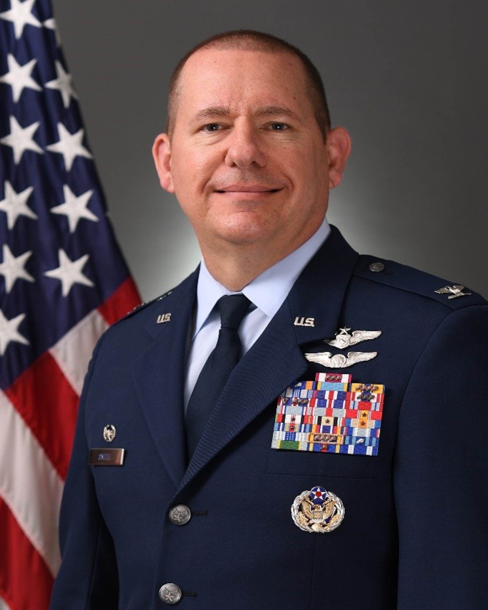 photo of a uniformed, US military member with a US flag in the background